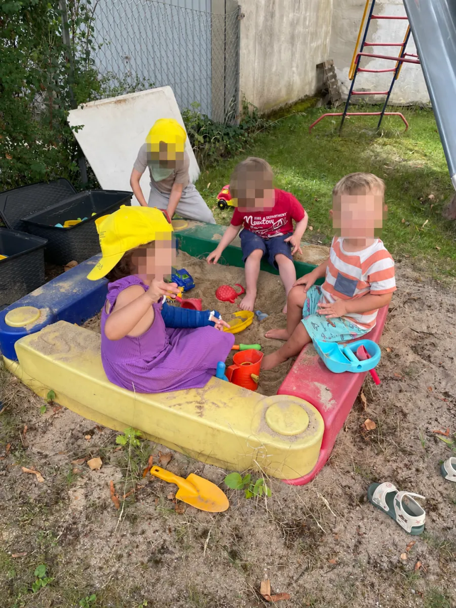 Kinder spielen im Sandkasten auf dem Spielplatz im Innenhof